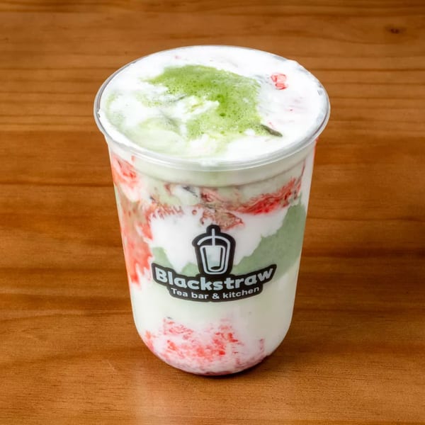 Blackstraw Tea Bar & Kitchen's layered drink with green matcha, white cream, and red fruit swirls.